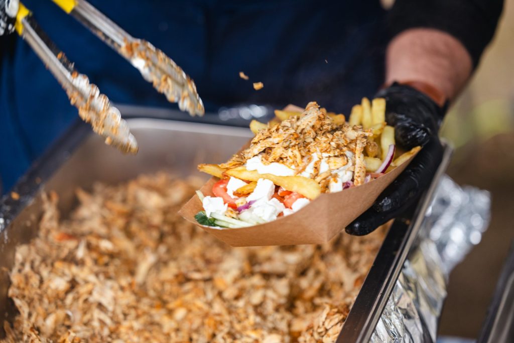 A chef preparing a plate of greek gyros.